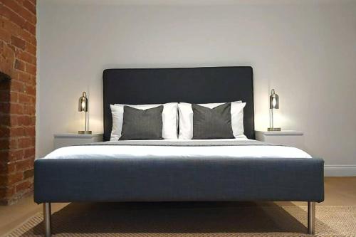 a bedroom with a bed with two lamps on both sides at Stylish Apartment in City Centre with Parking in Preston