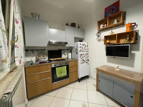 a kitchen with a stove and a refrigerator at TheMaki'sHouse in Fiumicino