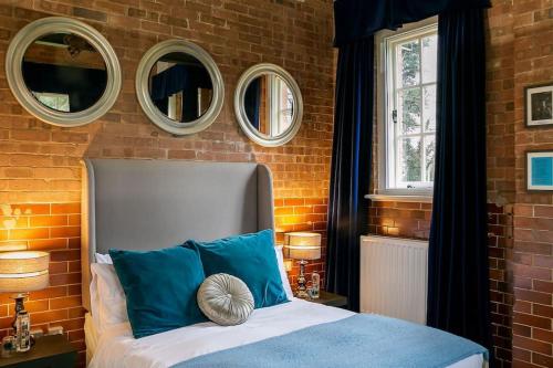 a bedroom with a bed with three mirrors on the wall at Duclos (Private Ensuite room) at Bicester Heritage in Bicester