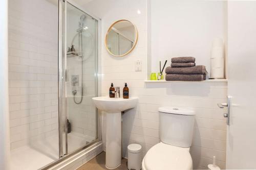 a bathroom with a shower and a toilet and a sink at Duclos (Private Ensuite room) at Bicester Heritage in Bicester