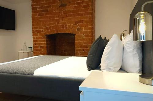 a bedroom with a bed with a brick wall at Stylish Apartment in City Centre with Parking in Preston