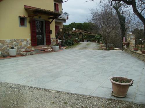 a patio in front of a house with a pot at Il Vecchio Cipresso in San Gimignano