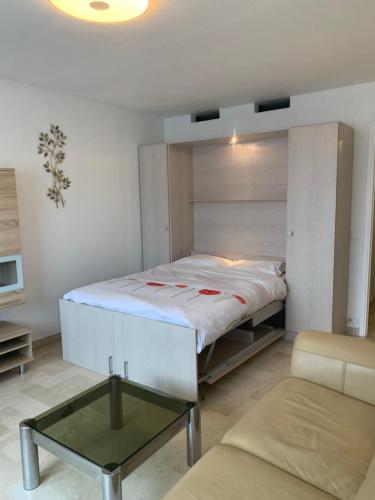 una camera con un grande letto e un tavolino di IDEAL SEJOUR à MANDELIEU a Mandelieu La Napoule