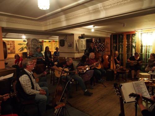 a group of people sitting in a room playing instruments at The Dundonnell Hotel in Dundonnell