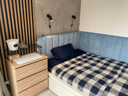 niewielka sypialnia z łóżkiem i komodą w obiekcie Komfortowy Domek Natura, w pobliżu Nadmorskiego Parku Krajobrazowego, 800 m od plaży w mieście Karwieńskie Błoto Drugie