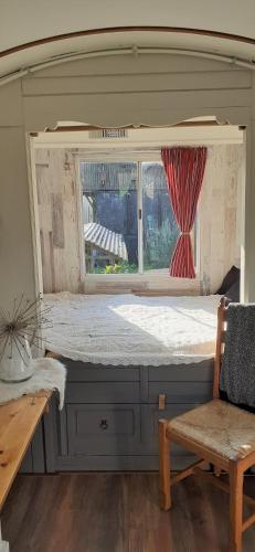 a large bed in a room with a window at Pipowagen Paarse Opal in Lienden
