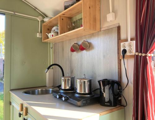 a kitchen counter with two pots and a sink at Pipowagen Paarse Opal in Lienden