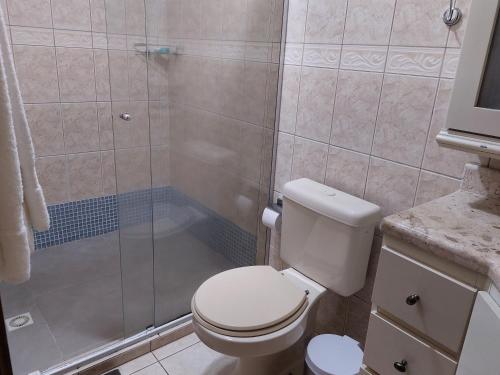 y baño con aseo blanco y ducha. en Cobertura Roloff, en Gramado