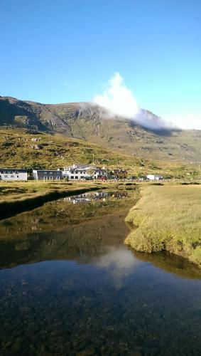 a small body of water with a mountain in the background at The Dundonnell Hotel in Dundonnell