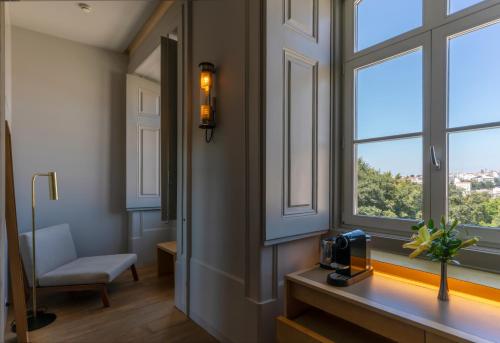 a room with windows and a desk with a chair at Verride Palácio Santa Catarina in Lisbon