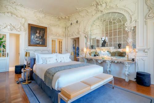 a bedroom with a large white bed and a mirror at Verride Palácio Santa Catarina in Lisbon