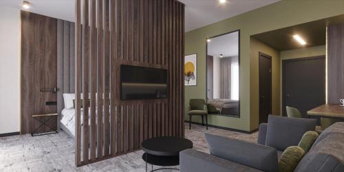 Una sala de estar con un sofá y un televisor. en Restoria Hotel***, en Radzyń Podlaski