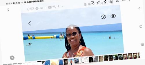 a woman in sunglasses and a picture of a beach at Dela de-Rose Guest House Negril Jamaica in Negril