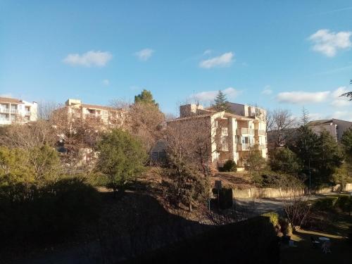 - une vue sur un bâtiment avec des arbres et des bâtiments dans l'établissement Studio "Le Rigaou", à Gréoux-les-Bains