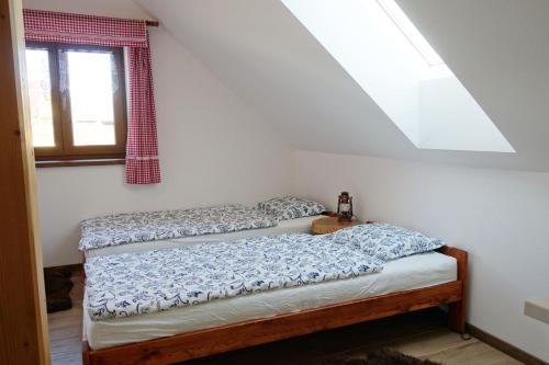 Duas camas num quarto com uma janela em Chalupa Luční Kvítí em Petrovice