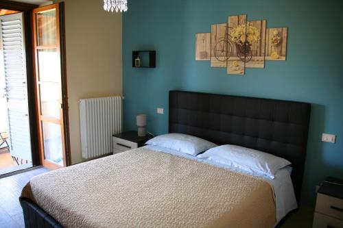 - une chambre avec un grand lit et un mur bleu dans l'établissement SUNNY HILL, à Monte San Savino