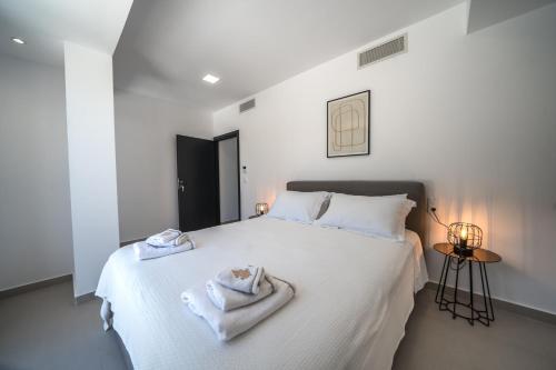 a bedroom with a white bed with towels on it at Villa Vivian Heated Private Swimming Pool & Jacuzzi in Georgioupolis