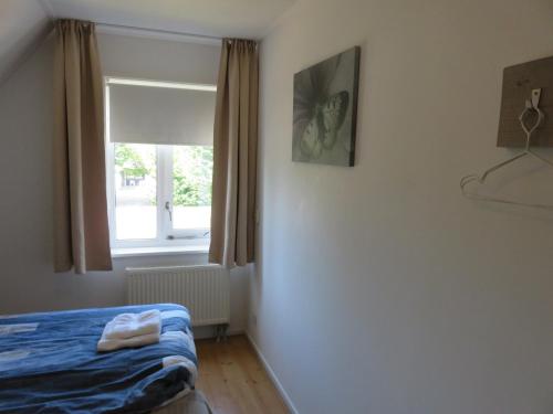 a bedroom with a bed and a window at Oostvaarders vakantiehuis in Almere