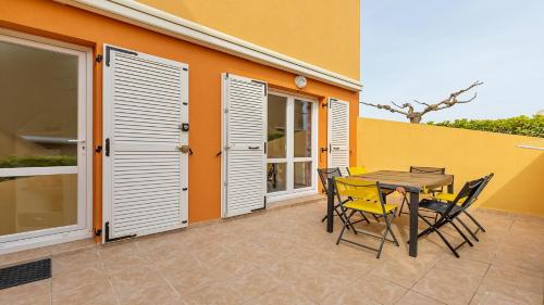 un patio avec une table et des chaises devant un bâtiment dans l'établissement Les 4 Soleils- 174- Appart moderne 4 pers, au Cap d'Agde