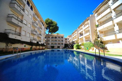 a swimming pool in the middle of two buildings at PLAYAMAR ORANGECOSTA 1 dormitorio in Alcossebre