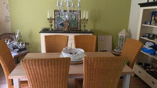 uma mesa de jantar com cadeiras de vime e uma mesa com uma tigela em Oase der Ruhe em Heideblick