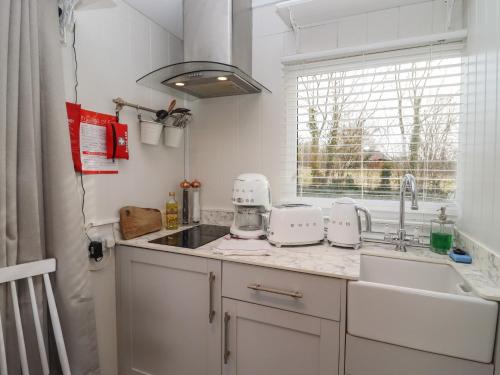 una cucina con due elettrodomestici bianchi su un bancone di Art Studio a Blandford Forum