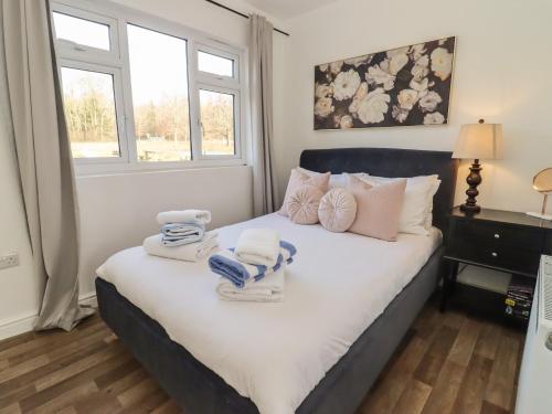 a bedroom with a bed with towels on it at Dreamwood in Blandford Forum