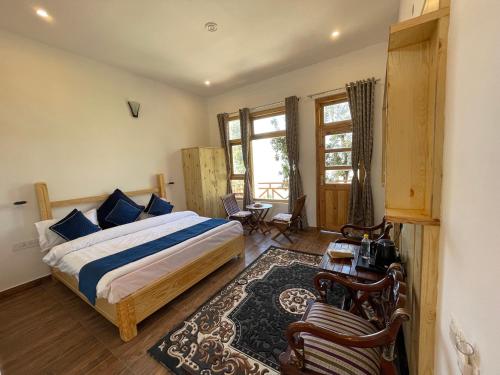 a bedroom with a bed and a table and chairs at Bagar Trails in Nainital