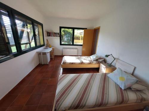 een kamer met 2 bedden, een tafel en ramen bij Villa Ana en Camallera (Alt Empordà) in Camallera