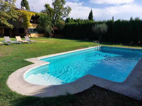 een zwembad in een tuin met enkele stoelen bij Villa Ana en Camallera (Alt Empordà) in Camallera