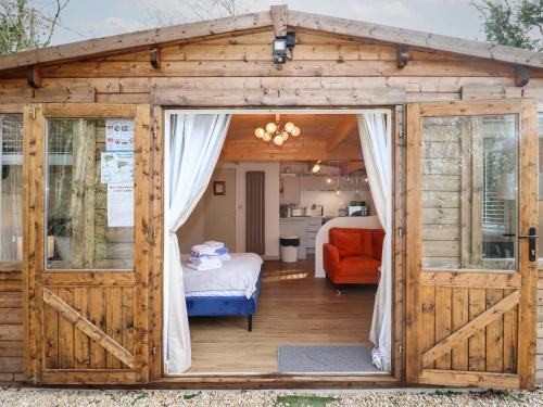 a wooden gazebo with a bedroom and a bed at Copper Beach in Blandford Forum