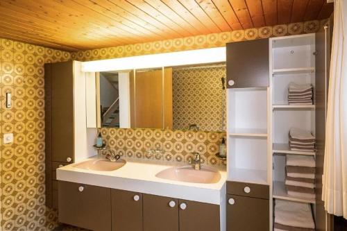 La salle de bains est pourvue de 2 lavabos et d'un miroir. dans l'établissement Ferienhaus Wühre, à Appenzell