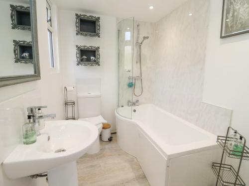 a bathroom with a sink and a tub and a toilet at Meadow in Blandford Forum