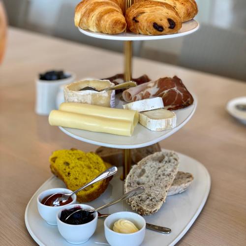 una bandeja de tres niveles de pan y bollería en una mesa en Verride Palácio Santa Catarina, en Lisboa
