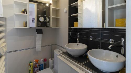 une salle de bains avec deux lavabos sur un comptoir dans l'établissement Les Estivales- 9H- Studio charme- 4 pers, au Cap d'Agde