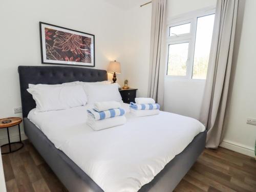 1 dormitorio con 1 cama blanca grande y ventana en Stillness, en Blandford Forum