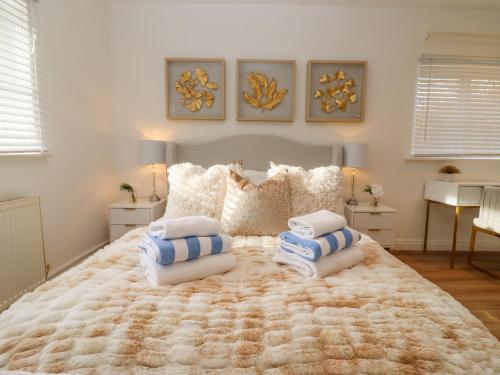 a bedroom with a large bed with pillows on it at Snowdrop in Blandford Forum