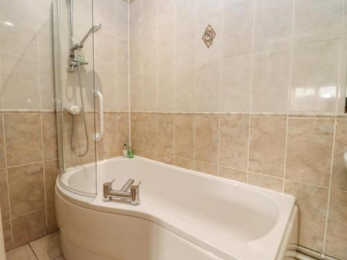 a bathroom with a bath tub and a toilet at Snowdrop in Blandford Forum