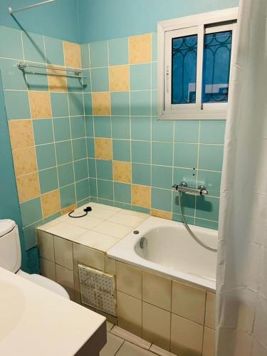 a bathroom with a tub and a toilet at Résidence Karamel Yaoundé Anguissa in Yaoundé