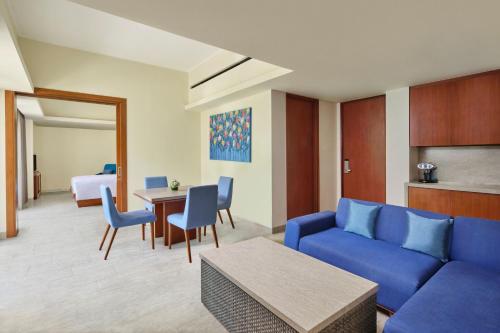 a living room with a blue couch and a table at Courtyard by Marriott Bali Nusa Dua Resort in Nusa Dua