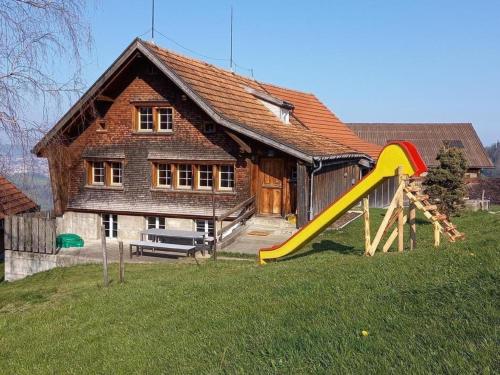 a house with a slide in front of it at Ferienhaus, Stöckli Klingenbuch 20 in Rehetobel