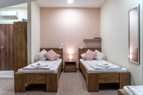 Zimmer mit 2 Betten und einer Lampe auf einem Tisch in der Unterkunft Rózsa Étterem & Panzió in Pécs