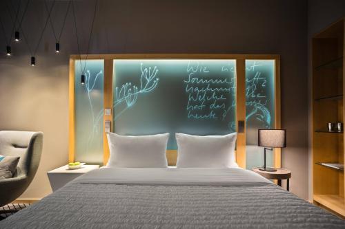a bedroom with a bed with writing on the wall at Le Méridien Hamburg in Hamburg