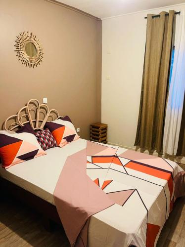 a bedroom with a bed with a colorful comforter at Résidence Karamel Yaoundé Anguissa in Yaoundé