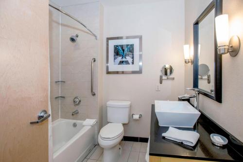 a bathroom with a toilet and a sink and a shower at Springhill Suites by Marriott Pueblo Downtown in Pueblo