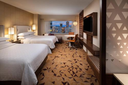 ein Hotelzimmer mit 2 Betten und einem TV in der Unterkunft Sheraton Grand Seattle in Seattle