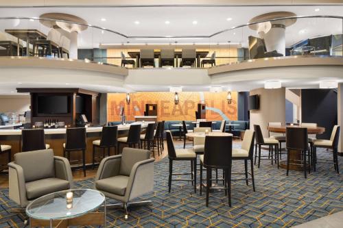a restaurant with tables and chairs and a bar at Courtyard by Marriott Minneapolis Downtown in Minneapolis