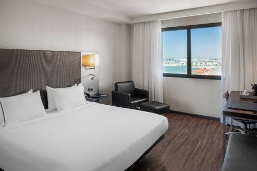 a hotel room with a bed and a desk and a window at AC Hotel Algeciras by Marriott in Algeciras