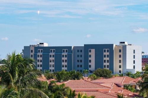 a large blue building with palm trees in front of it at SpringHill Suites by Marriott Cape Canaveral Cocoa Beach in Cape Canaveral