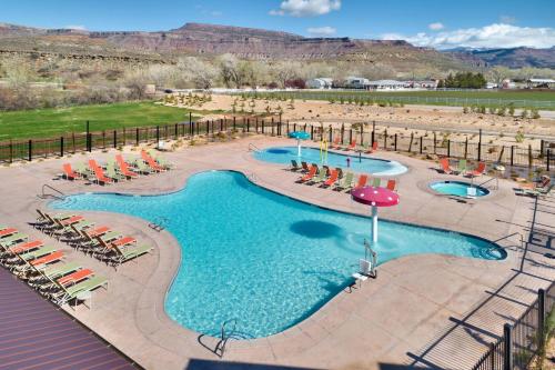a pool with chairs and umbrellas at a resort at Fairfield Inn & Suites by Marriott Virgin Zion National Park in Virgin